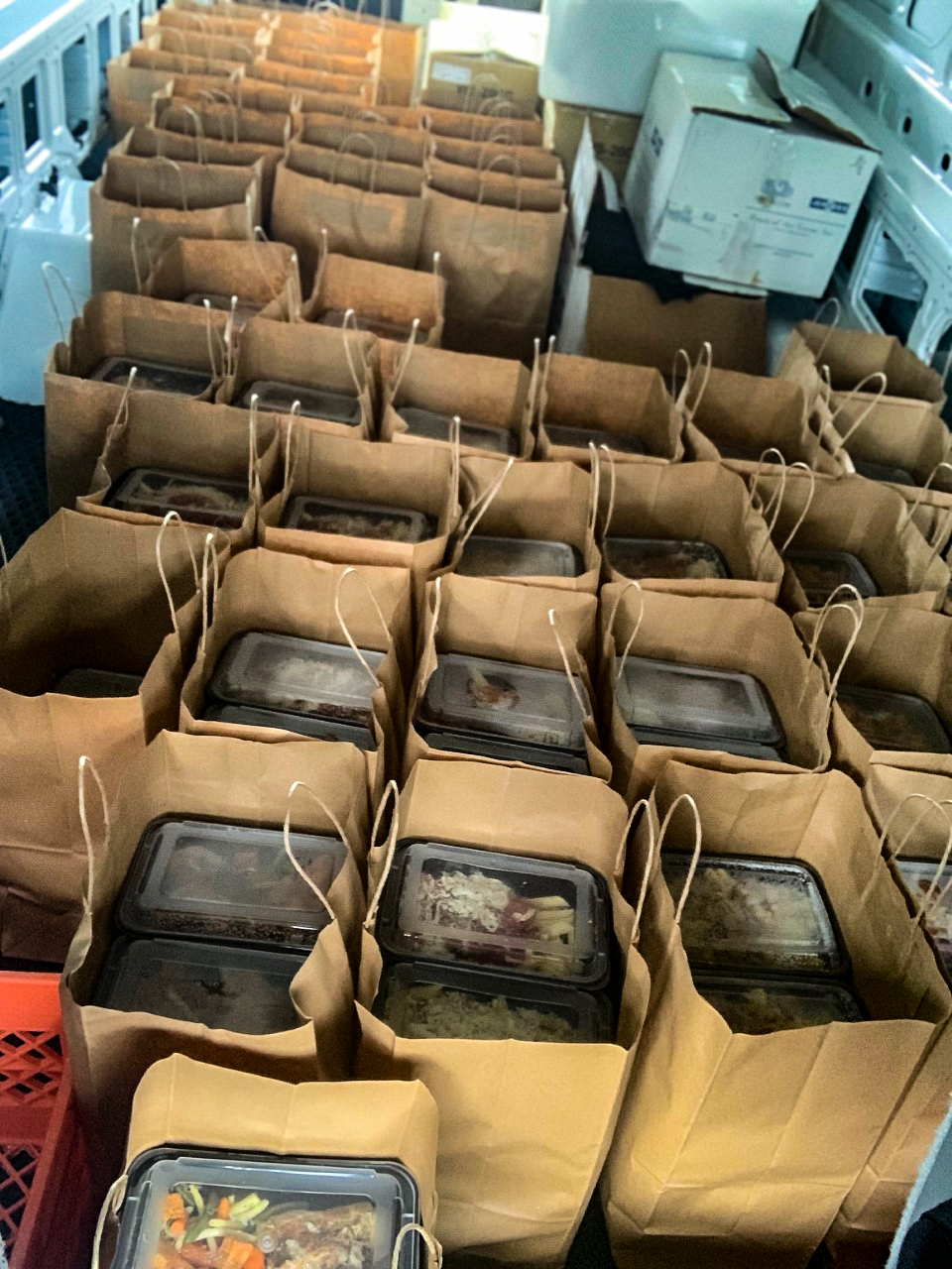 Brown bags loaded with meal containers for delivery